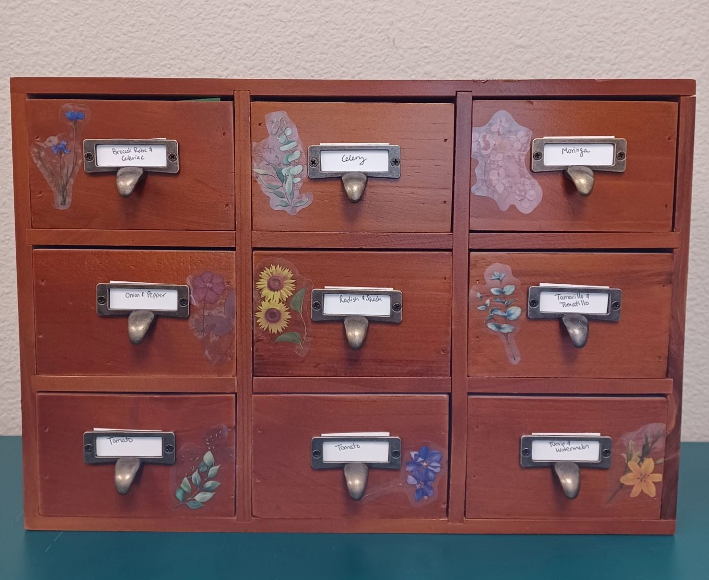 Wooden card catalog with flower stickers on closed drawers